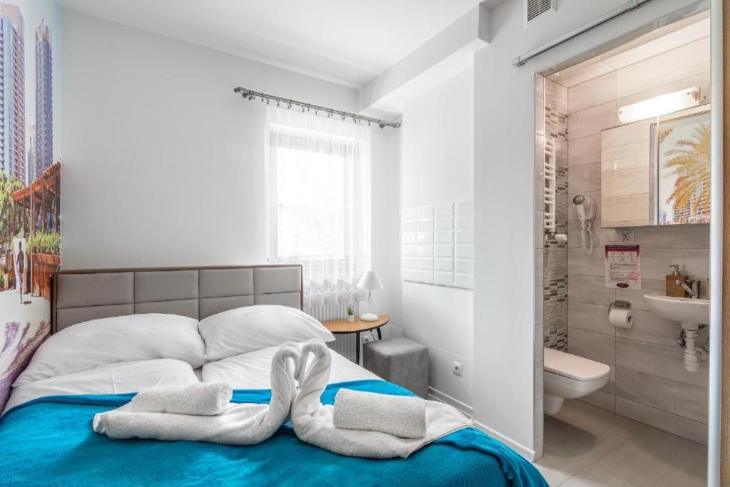a bedroom with a bed with towels on it at Studio pokój Dubaj Centrum Zakopane in Zakopane