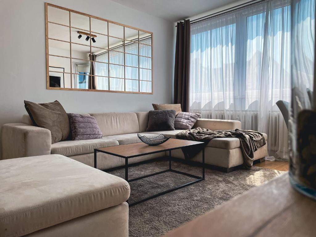 a living room with a couch and a table at Kirchturm-Panorama - Apartment mit Balkon im Herzen von Braunschweig in Braunschweig