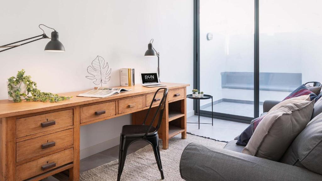 a desk with a laptop and a chair in a room at RUN Aveiro in Aveiro