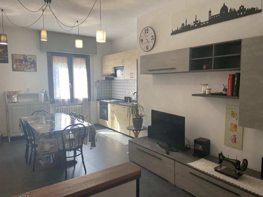 eine Küche und ein Esszimmer mit einem Tisch und einer Uhr an der Wand in der Unterkunft Casa Stella in Scandicci