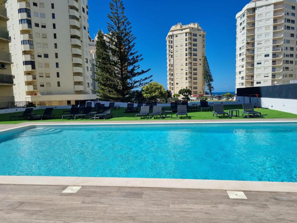 a swimming pool in the middle of two buildings at AlgarPapa Rooms in Armação de Pêra