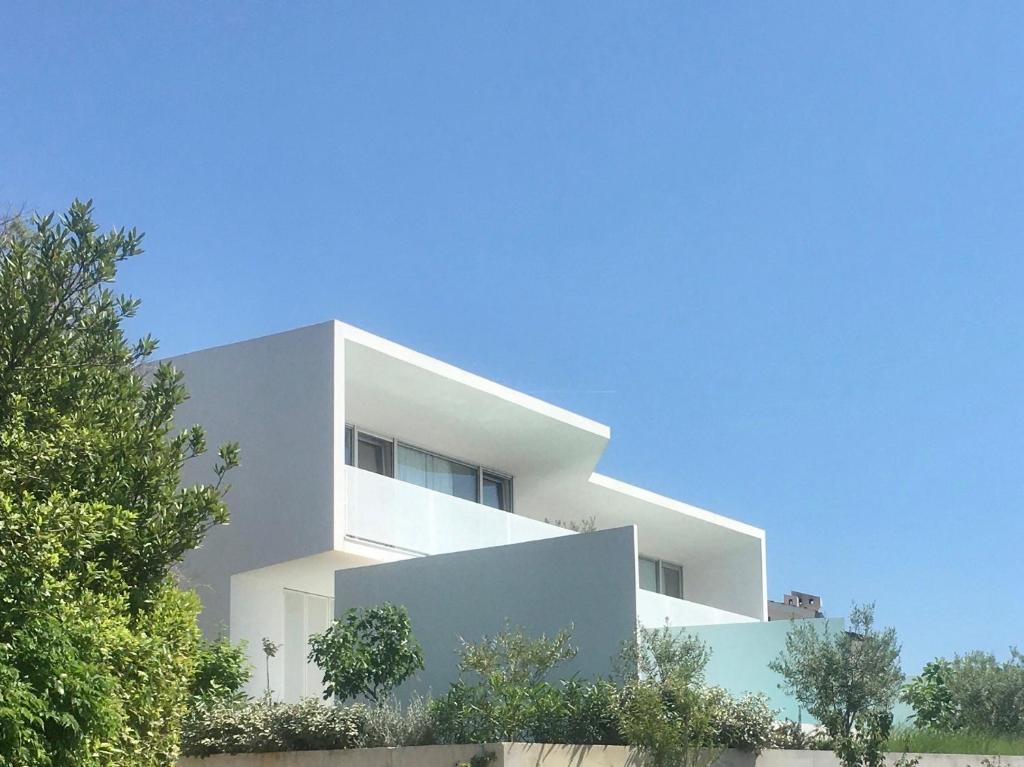 a white building with trees in front of it at Vila Villaarh in Krk