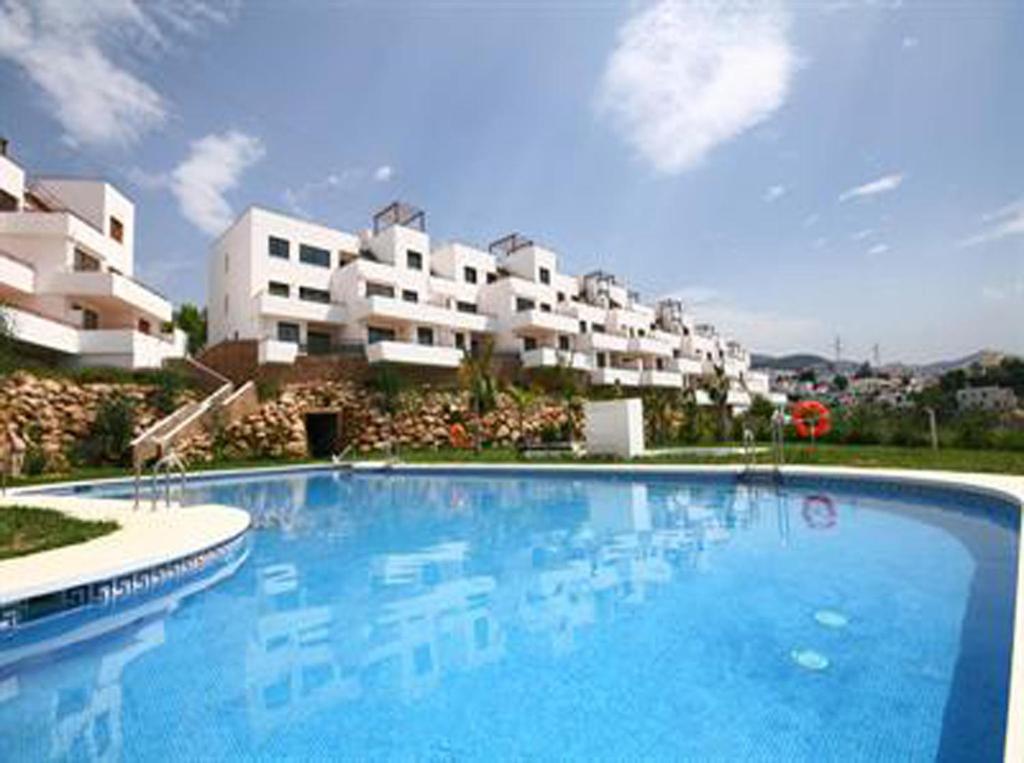 a large swimming pool in front of a building at Andaluz Apartments Mar de Nerja in Nerja