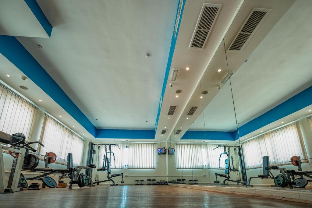 a gym with blue ceilings and windows and tread machines at THE PARK HOTEL Formerly Al Jawhara Gardens in Dubai