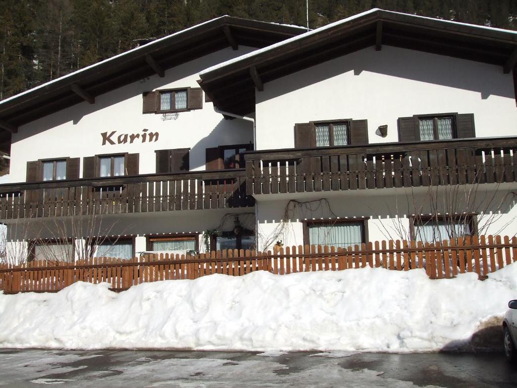 ein Gebäude mit Schnee davor in der Unterkunft Appartamenti Callori Karin Codici Cipat 22039-AT-53550 AT-53551 in Canazei