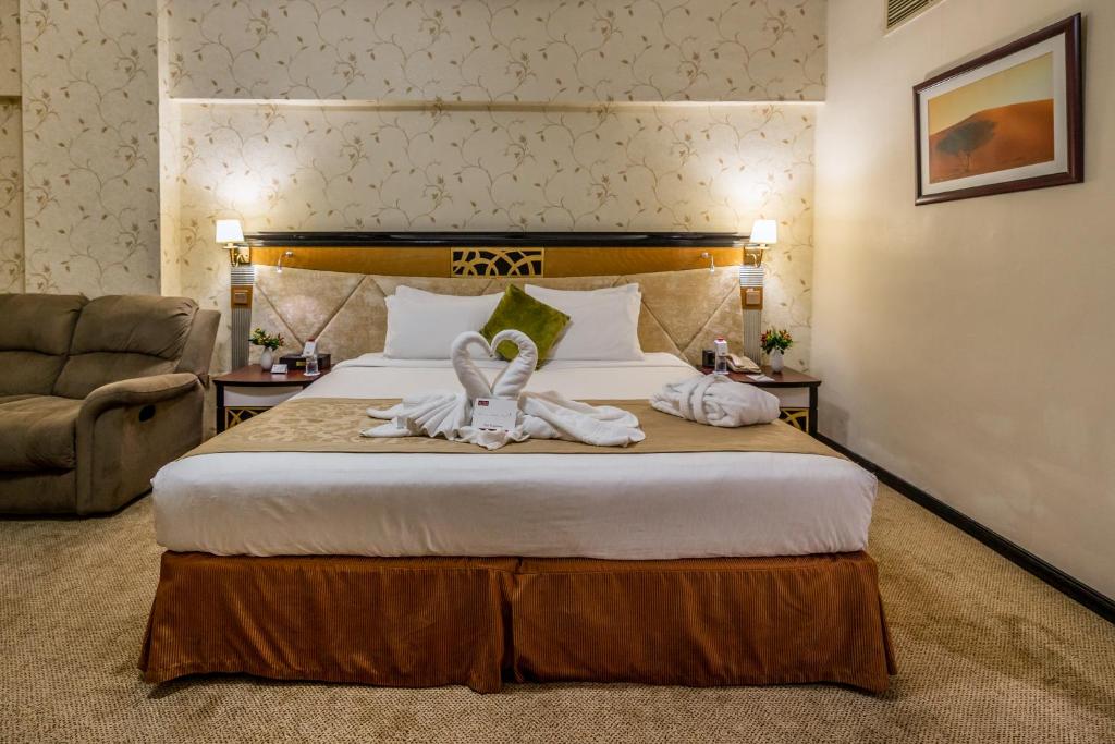 a hotel room with a bed with towels on it at THE PARK HOTEL Formerly Al Jawhara Gardens in Dubai