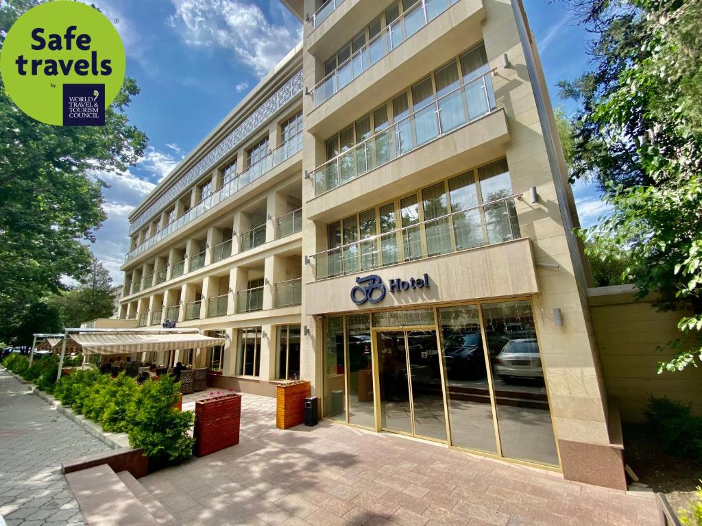 an office building with a sign that reads safe travels at B Hotel Bishkek in Bishkek