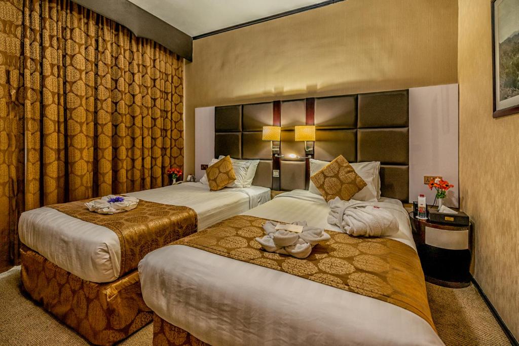 a hotel room with two beds in a room at THE PARK HOTEL Formerly Al Jawhara Gardens in Dubai