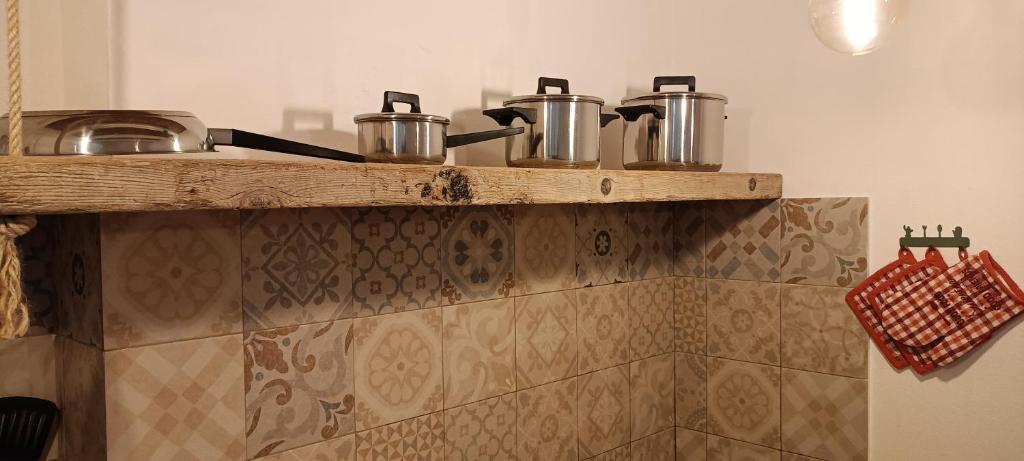 zwei Töpfe und Pfannen auf einem Regal in einer Küche in der Unterkunft Holiday home in Palermo