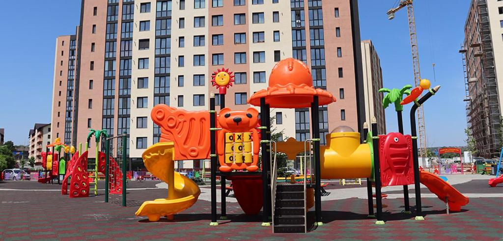 un parque infantil frente a un gran edificio en Shelter House, en Iaşi