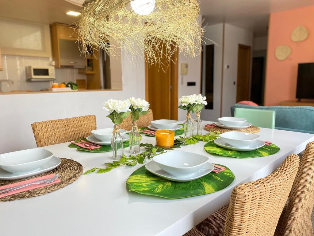 einen Esstisch mit weißer Tischdecke und grünem Platz in der Unterkunft Ático Divina Home - Rias Baixas in Vilagarcia de Arousa