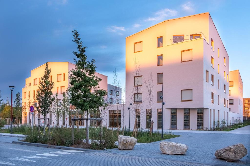 un edificio con dos rocas grandes delante de él en The Originals Boutique Hôtel Amiens Sud en Amiens