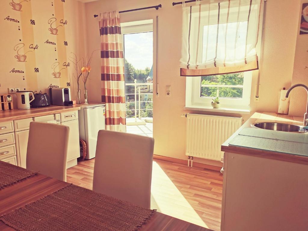 een keuken met een tafel en stoelen en een raam bij Schöne, helle, ruhige Wohnung und Wellness Sauna 