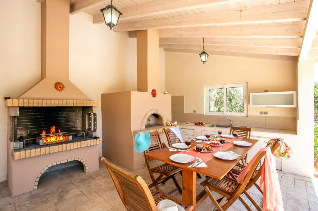 kuchnia i jadalnia ze stołem i kominkiem w obiekcie Villa Terpsy by Villa Plus w Retimnie
