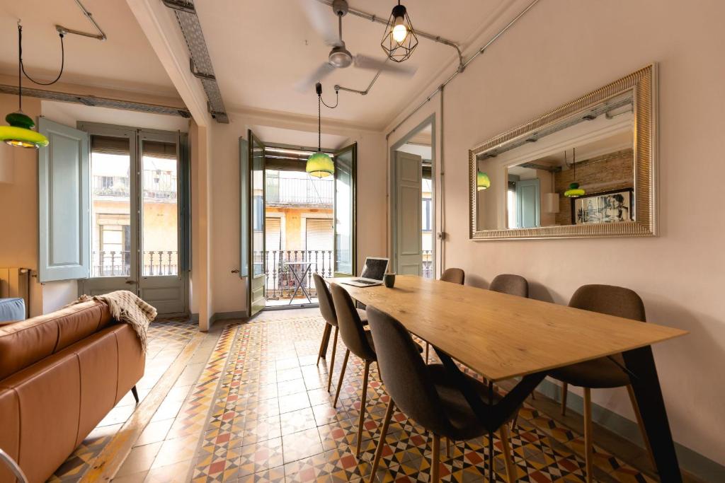a dining room with a table and chairs and a couch at Bravissimo Les Rajoles, Unique 3-bedroom apartment in Girona