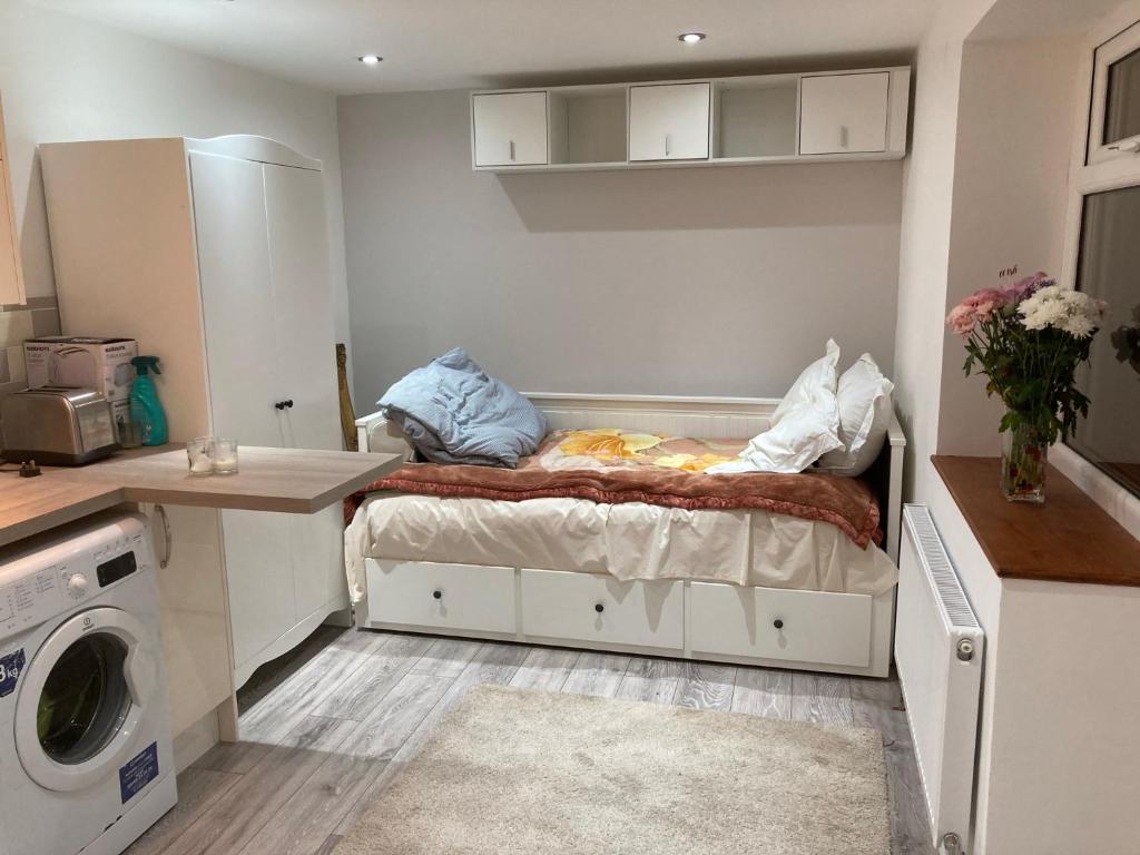a small room with a bed and a washing machine at London retreat in Golders Green