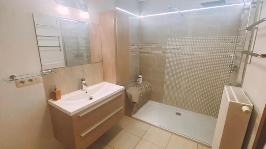La salle de bains est pourvue d'un lavabo, d'une douche et d'une baignoire. dans l'établissement Maison à 3,2km de l’aéroport, à Charleroi