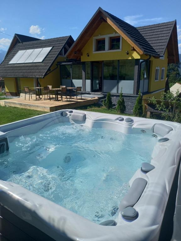 a hot tub in front of a house at Romantic Mountain Chalet and SPA Tubej in Bohinj