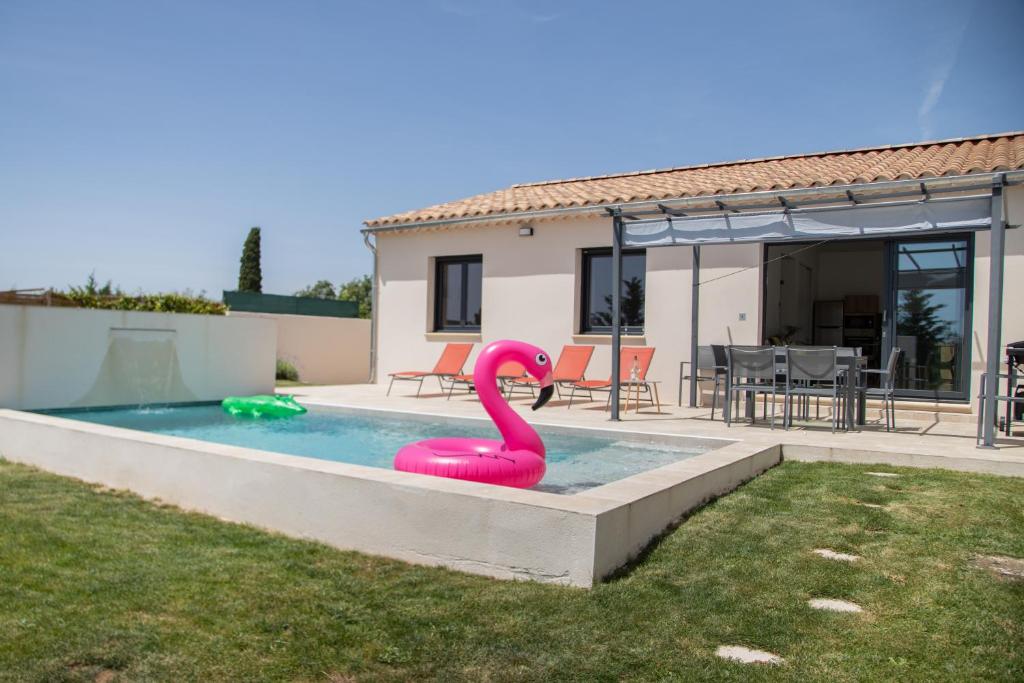a pink inflatable flamingo in a swimming pool at Les Villas des Fontaines in Saumane-de-Vaucluse