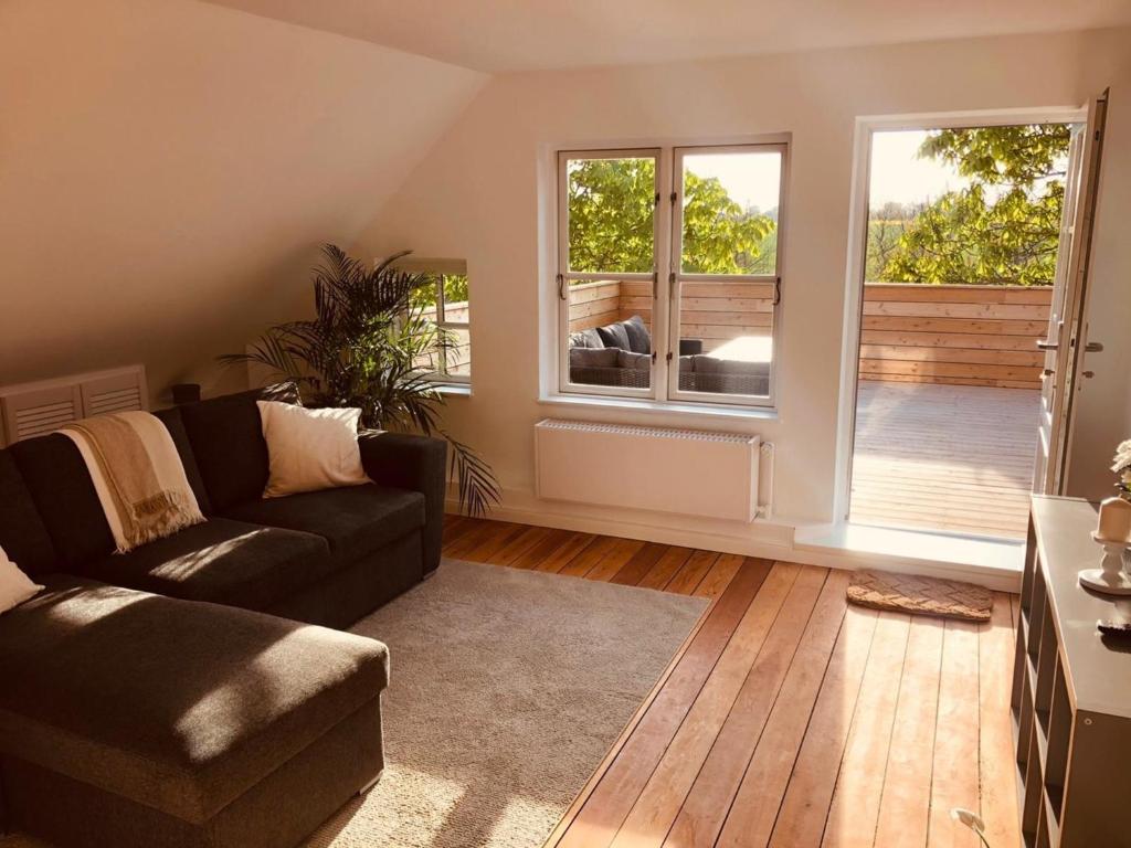 a living room with a couch and a large window at Urlaub auf Mittelhof in Großenbrode