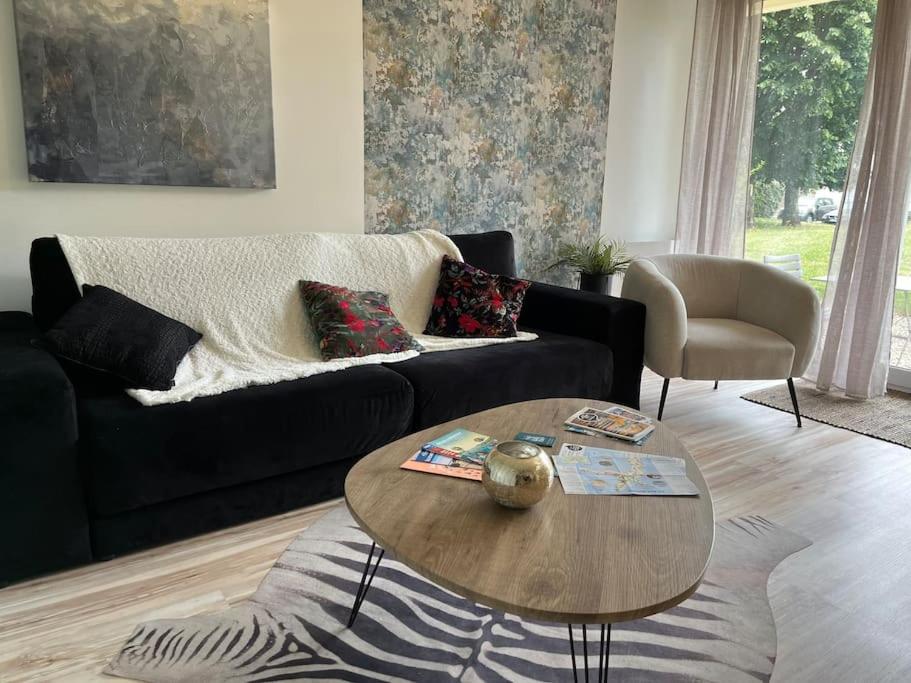 un salon avec un canapé noir et une table dans l'établissement Le Roosevelt - Proche centre - Parking privé, à Vannes
