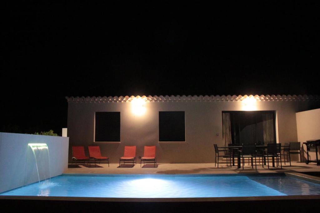 a swimming pool in front of a house at night at Les Villas des Fontaines in Saumane-de-Vaucluse