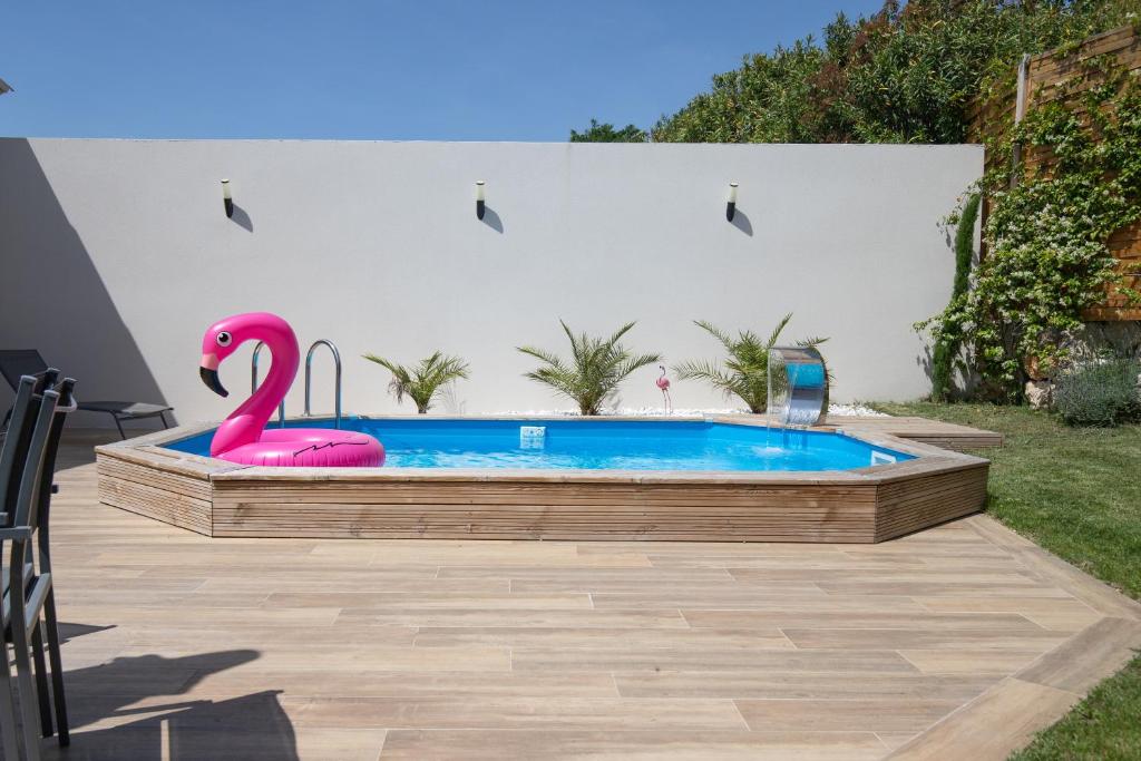 a pool with a pink flamingo in a backyard at Les Villas des Fontaines in Saumane-de-Vaucluse