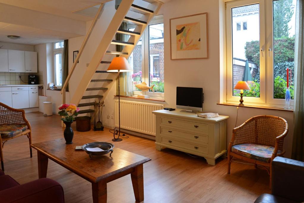 sala de estar con escalera y mesa en Casa al Mulino, en Valkenburg