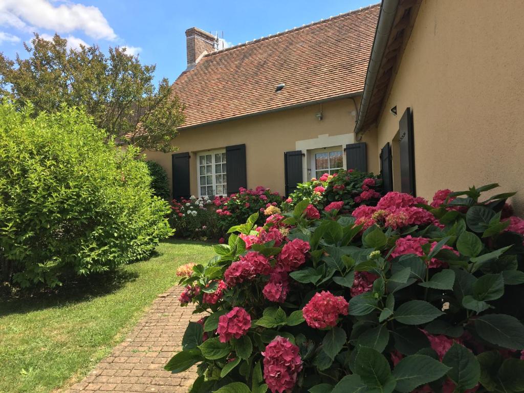 a garden with pink flowers in front of a house at CATHERINE & DOMINIQUE in Marigné-Laillé