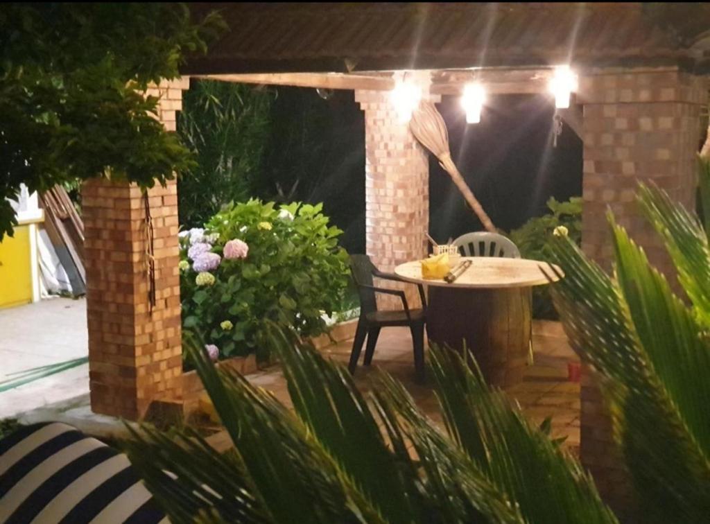eine Terrasse mit einem Tisch und Stühlen im Garten in der Unterkunft VILLA ANDREA GAETA in Gaeta