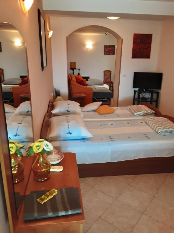 a bedroom with two beds and a mirror at Apartments Zlosilo in Orasac