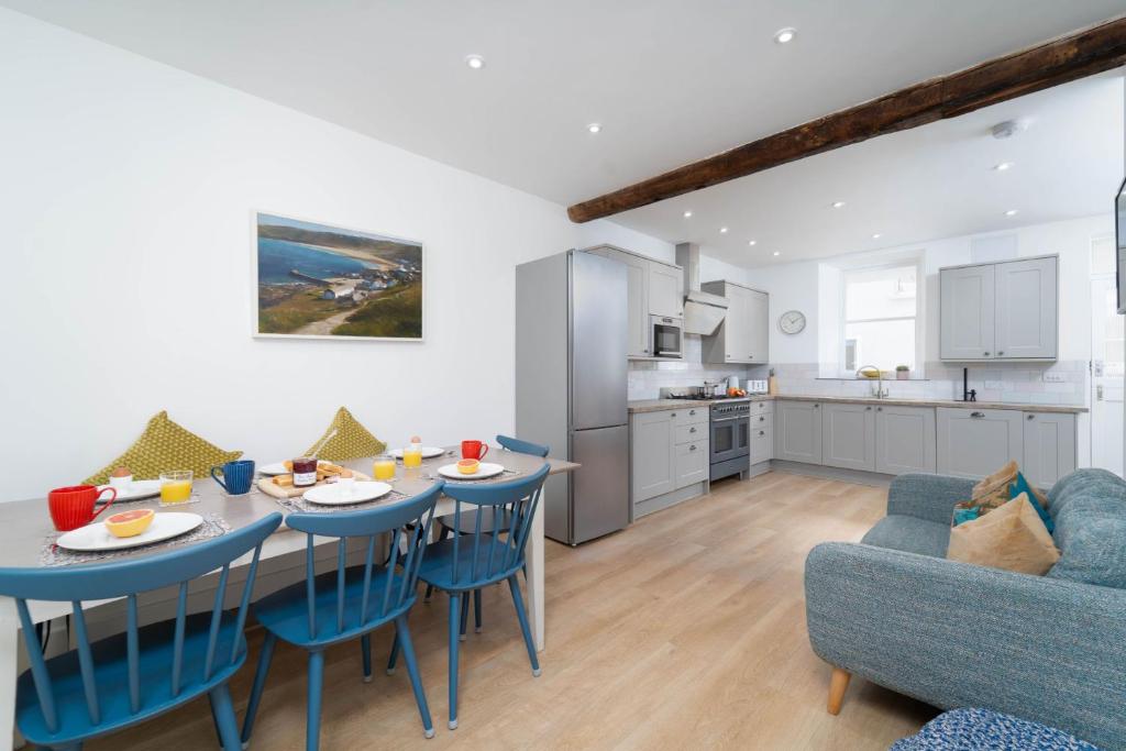 a kitchen and a living room with a table and chairs at Harbour Moorings in St Ives