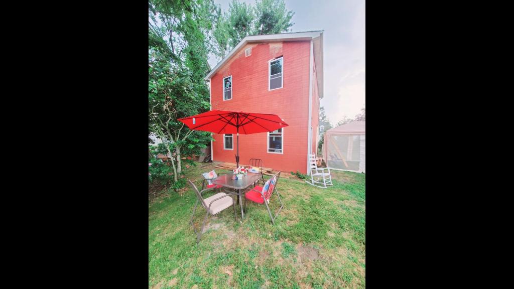 a red barn with a table and a red umbrella at Room in Cabin - Camping Cabin With Sauna Access 2nd Fl- in Dover