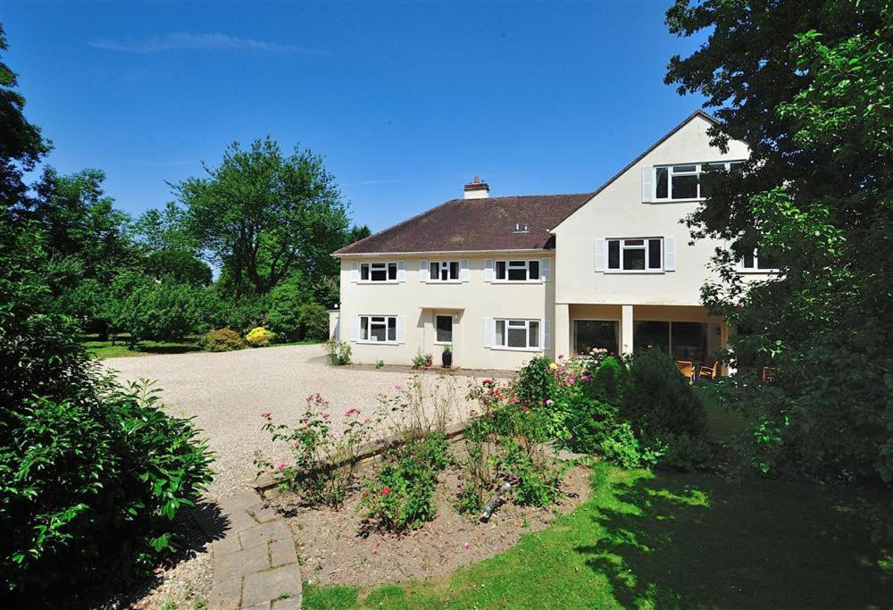 una gran casa blanca con un jardín delante de ella en The Orchard Country House en Rousdon