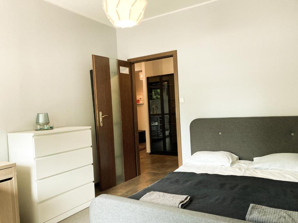 a bedroom with a bed and a dresser and a door at Apartment Gdansk Close to Oldtown in Gdańsk