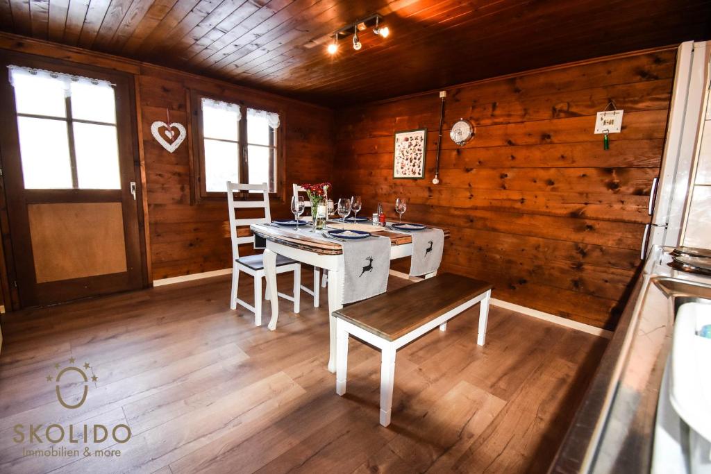 a dining room with a table and chairs in a cabin at Cosy Chalet in Brig-Glis in Glis