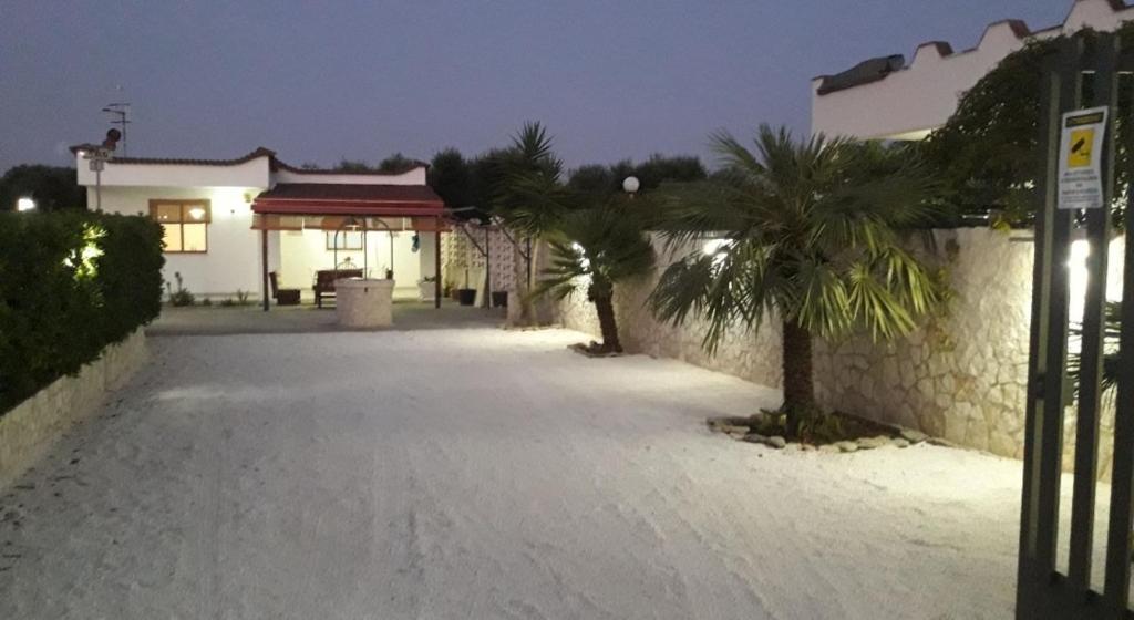 a street with a building and a palm tree at Casa vacanze immersa nelle campagne salentine in Monacizzo