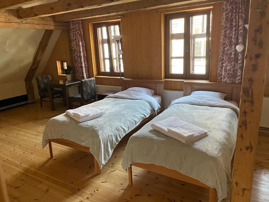 two twin beds in a room with windows at Kapteinis in Liepāja