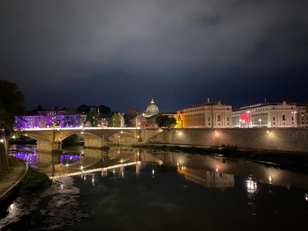 un puente sobre un río en una ciudad por la noche en Ottaviano 9 Little Suite, en Roma