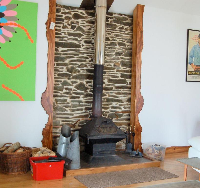 a stone wall with a stove in a room at The Annex, Kilbride Farmhouse in Dunoon