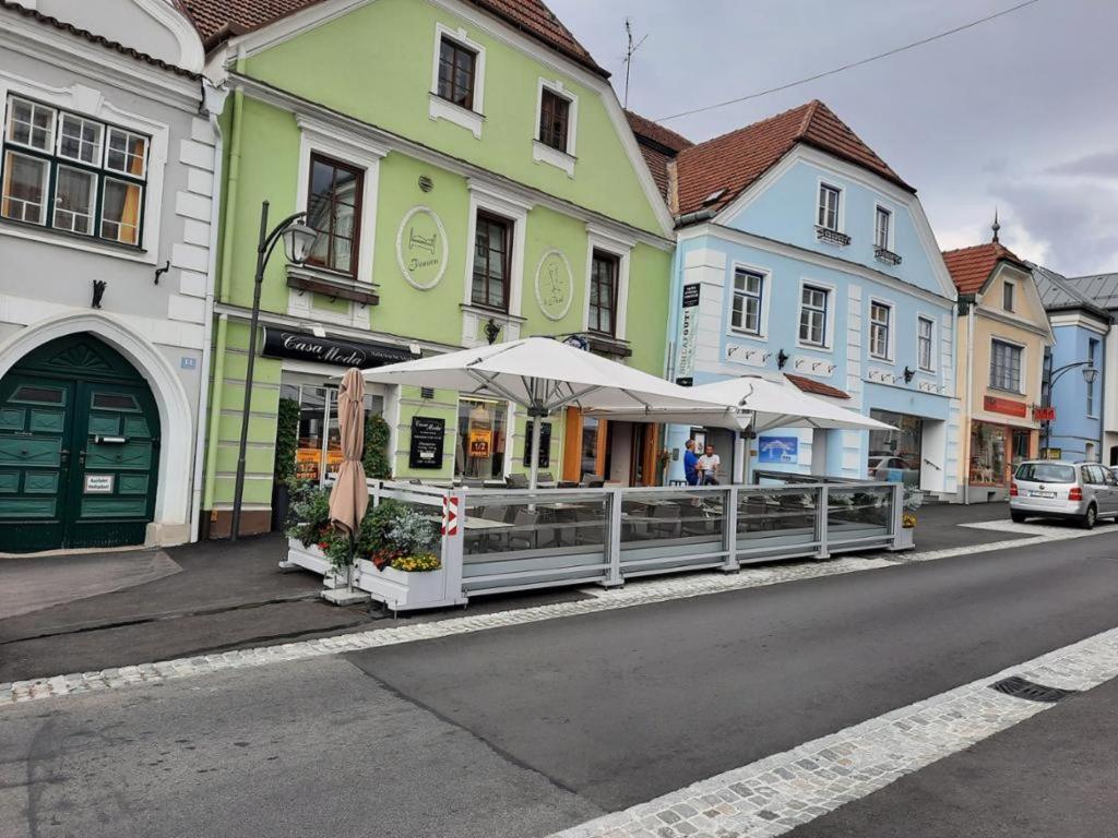 uma rua com um restaurante com guarda-sóis no passeio em Frühstückspension Reinhard Todt em Zwettl Stadt