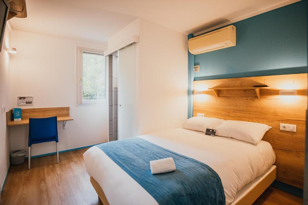 ein Schlafzimmer mit einem großen Bett und einer blauen Wand in der Unterkunft Kyriad Direct Bordeaux Est Lormont in Lormont