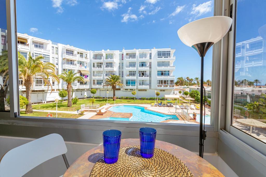 a table in a room with a view of a building at CANARIAN HOLIDAY HOME - Luxury Condo near Yumbo in San Bartolomé