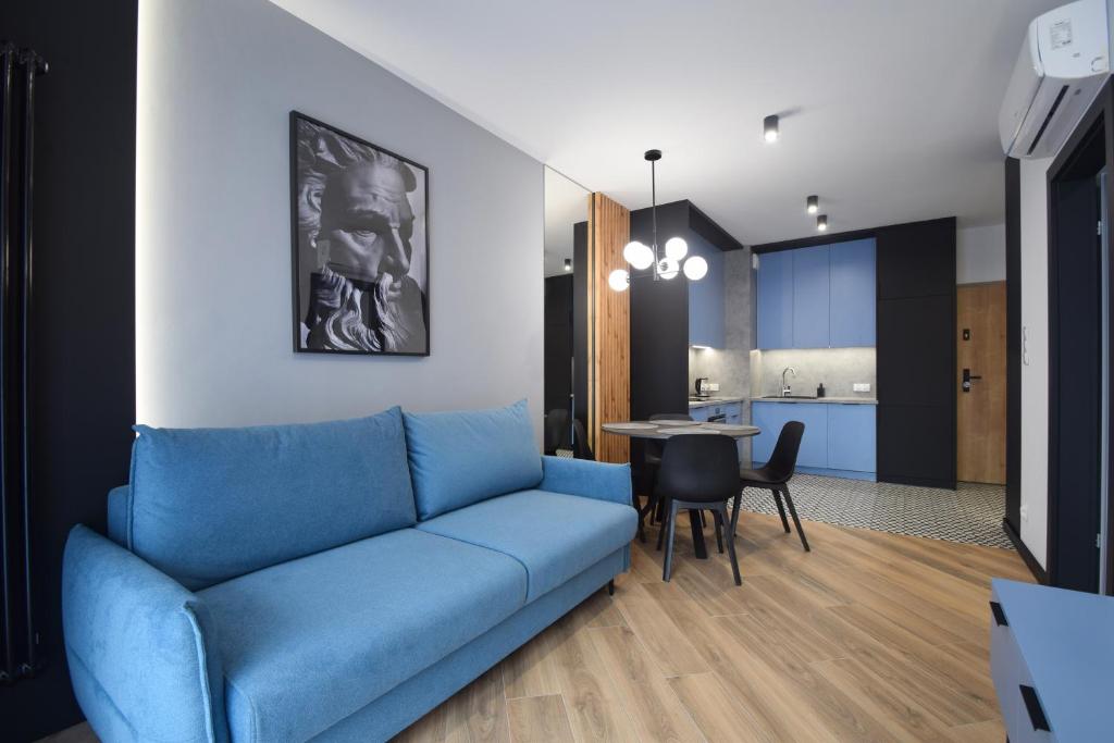 uma sala de estar com um sofá azul e uma mesa em Apartamenty LookAp Ustronie Morskie I przy plaży em Ustronie Morskie