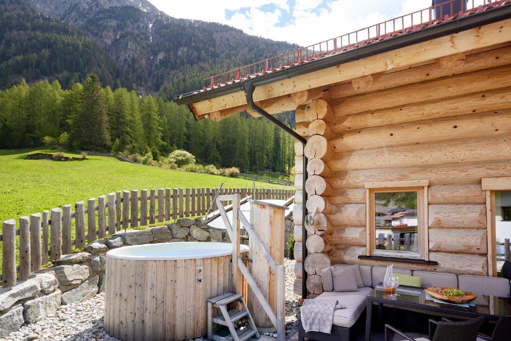 een houten hut met een hot tub op een patio bij Chalet Resort Sölden in Sölden