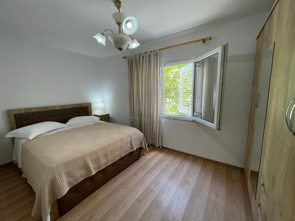 a bedroom with a bed and a window at Lovely one-bedroom apartment with private entrance in Tirana