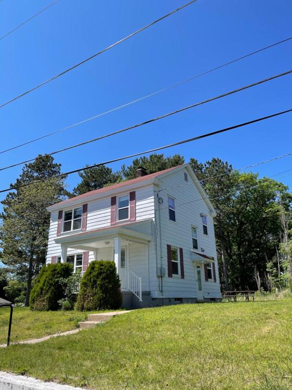 uma casa branca com um telhado rosa numa colina em Captain's Residence em Marquette