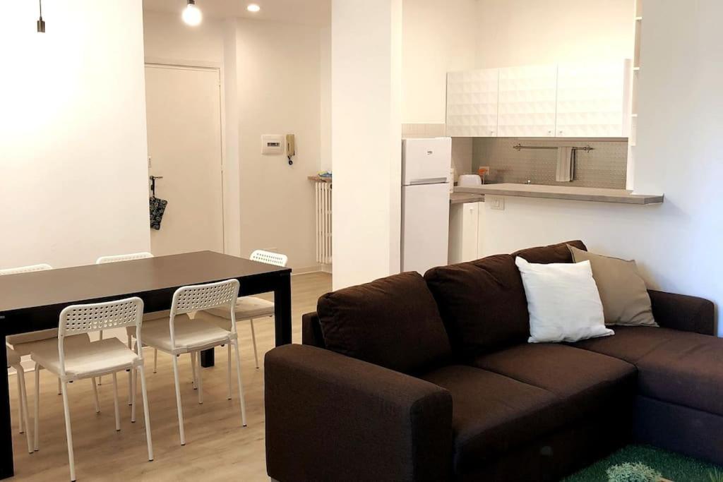 ein Wohnzimmer mit einem Sofa, einem Tisch und Stühlen in der Unterkunft appartmentslapiazzetta - n.4 in Sesto Calende