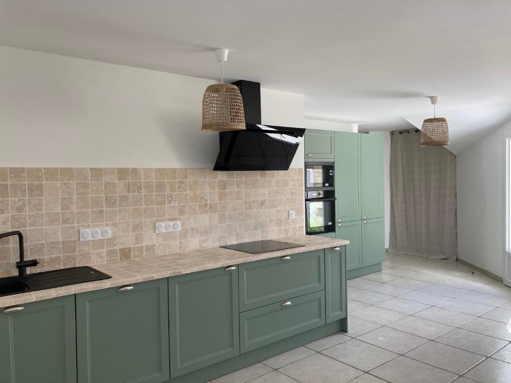 a kitchen with green cabinets and a sink at Locations Ile de Ré in Sainte-Marie-de-Ré