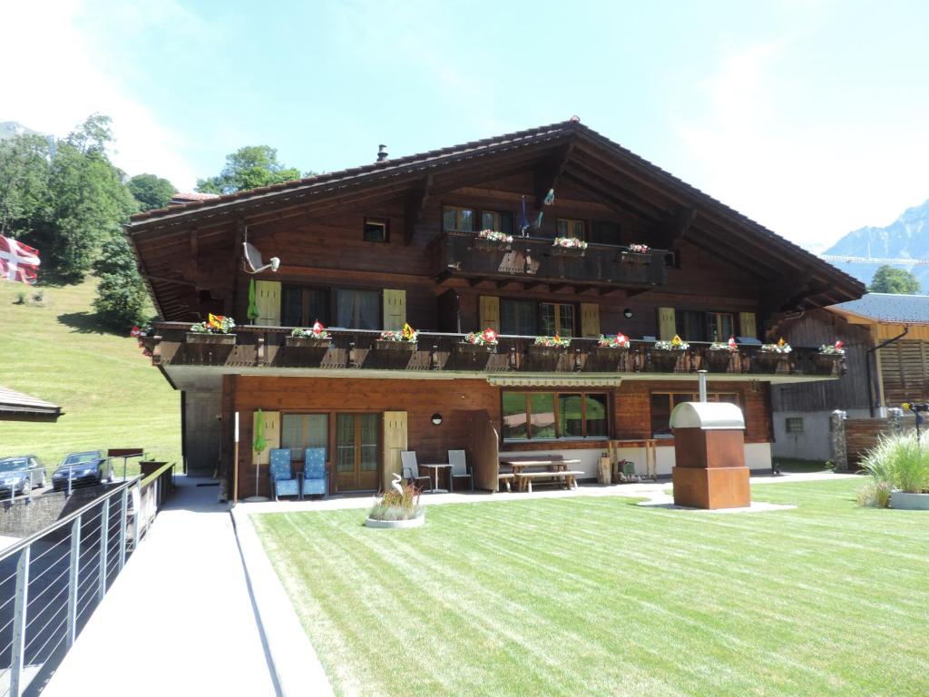 una casa grande con césped delante en Chalet Schwendiboden, en Grindelwald